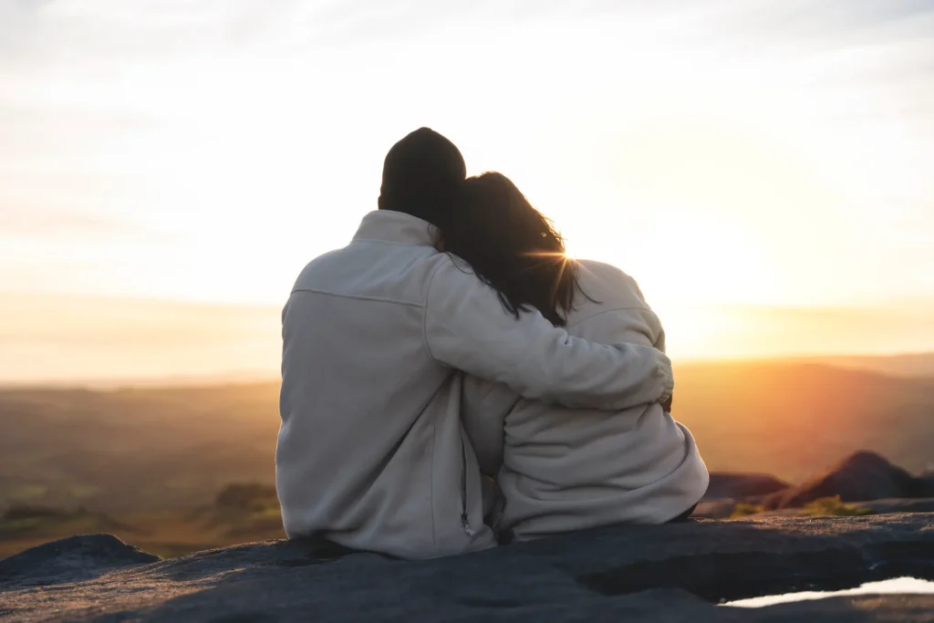 Soulmates embracing looking into the sunset satisfied with the feeling of knowing they have found each others perfect match